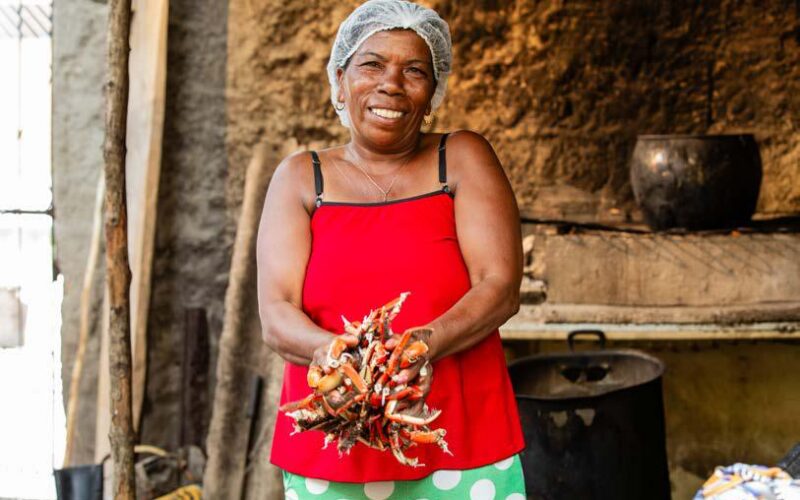 Mulher com caranguejos no litoral sul da Bahia